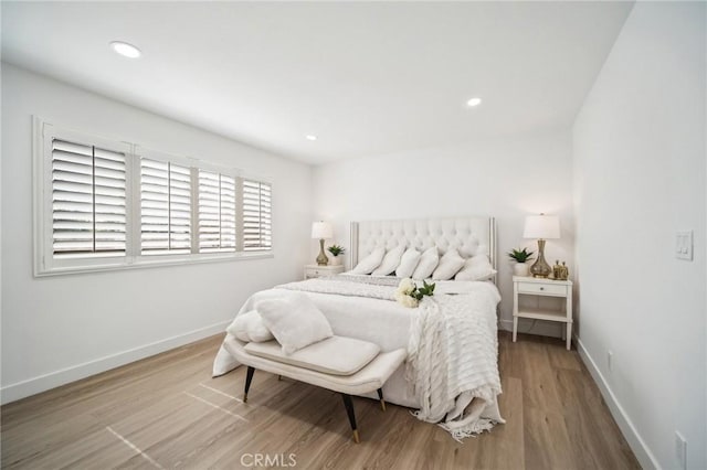 bedroom featuring baseboards, wood finished floors, and recessed lighting