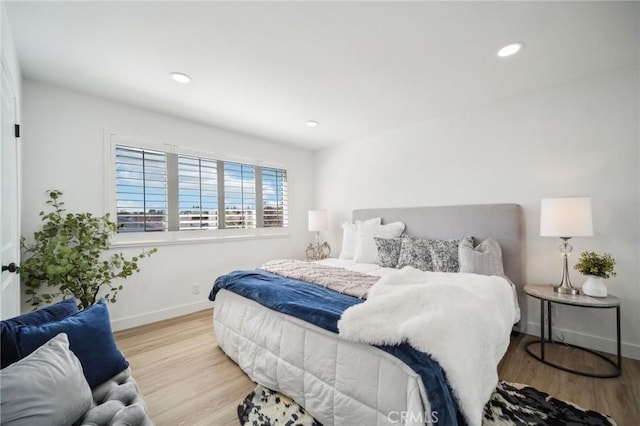bedroom with baseboards, wood finished floors, and recessed lighting