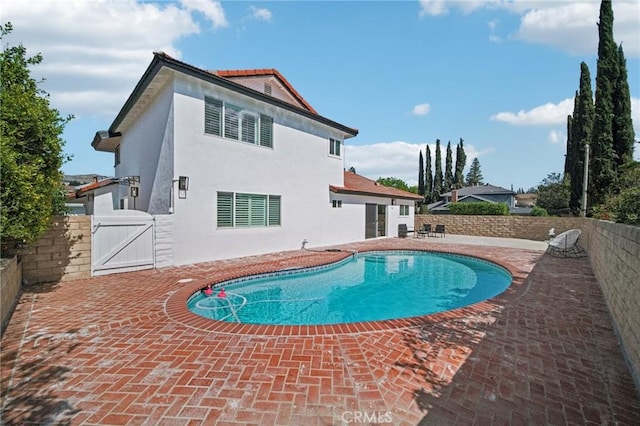 view of pool featuring a patio area, a fenced backyard, a fenced in pool, and a gate