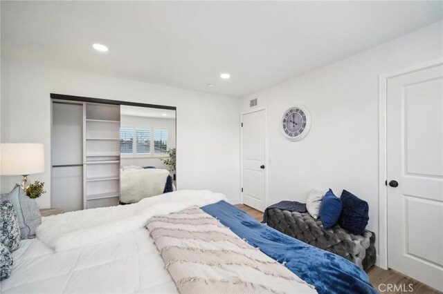 bedroom featuring wood finished floors, visible vents, and recessed lighting
