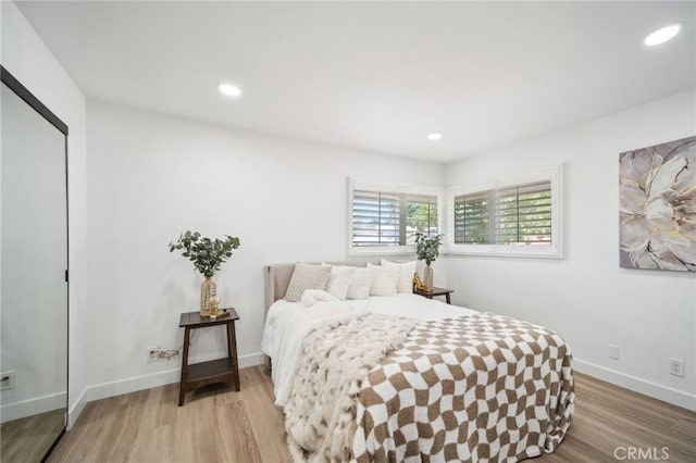 bedroom featuring recessed lighting, light wood-style flooring, a closet, and baseboards