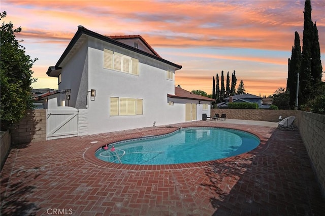 view of swimming pool featuring a fenced backyard, a fenced in pool, a gate, and a patio