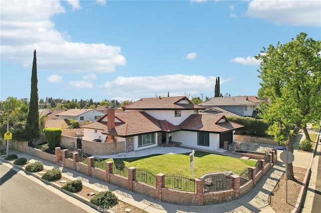 view of front of property featuring a fenced front yard, a tiled roof, a front lawn, a residential view, and stucco siding