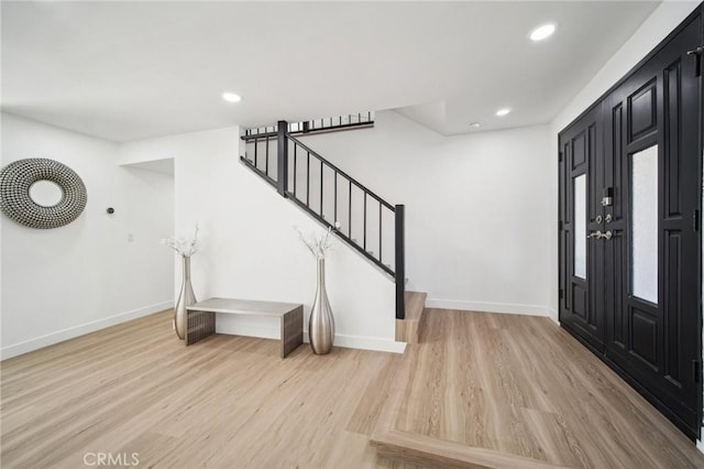 foyer entrance with recessed lighting, light wood-style floors, stairway, and baseboards