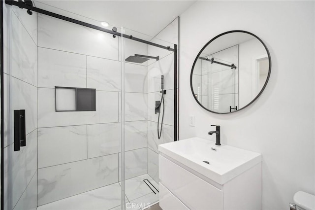 bathroom featuring vanity, toilet, and a stall shower