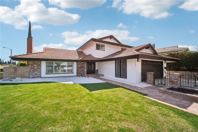 view of front of house with an attached garage, a front lawn, fence, and stucco siding