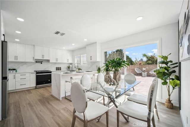 dining space featuring light wood-type flooring, visible vents, and recessed lighting
