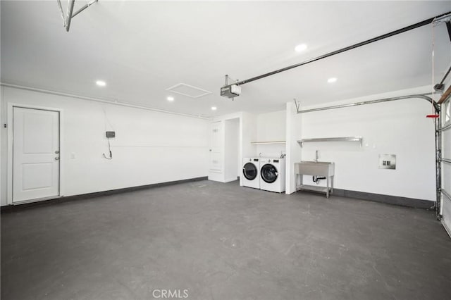garage featuring a sink, separate washer and dryer, a garage door opener, baseboards, and recessed lighting