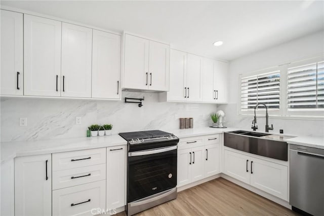kitchen featuring white cabinetry, stainless steel appliances, and a sink