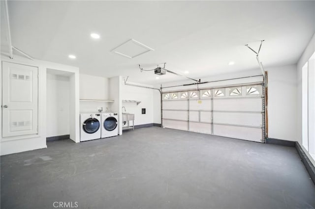 garage with recessed lighting, a garage door opener, a sink, baseboards, and washer and dryer