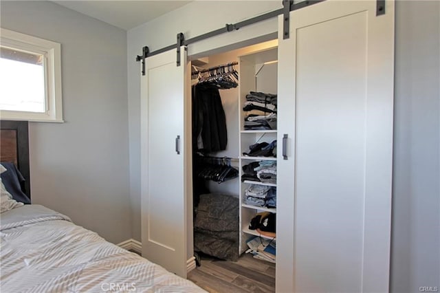 8037 Cactus Cir, Buena Park, CA 90620 - bedroom featuring a barn door, wood finished floors, a closet, and baseboards