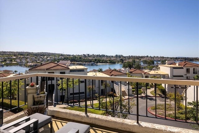 balcony featuring a residential view and a water view