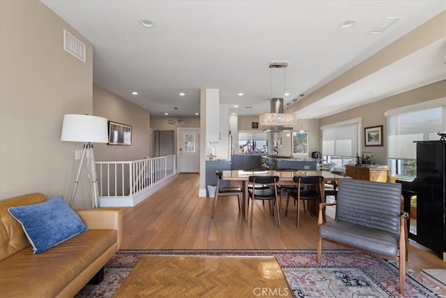 living room featuring light wood finished floors, visible vents, and recessed lighting