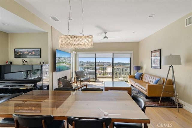 dining area featuring wood finished floors, visible vents, baseboards, and ceiling fan