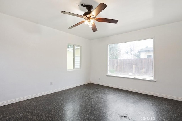 spare room with baseboards and ceiling fan