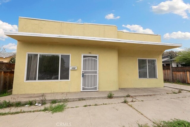 back of property featuring stucco siding, fence, and a patio area