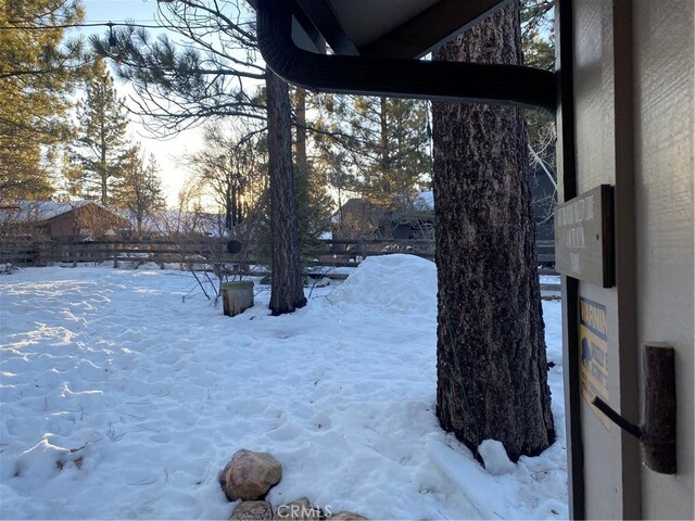 yard covered in snow featuring fence