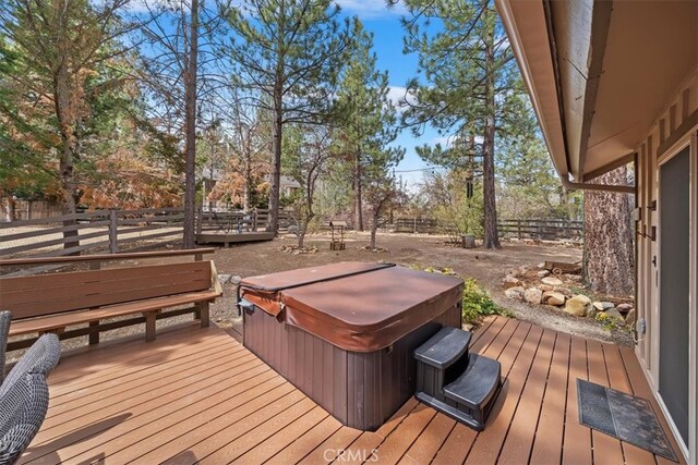 deck featuring fence and a hot tub