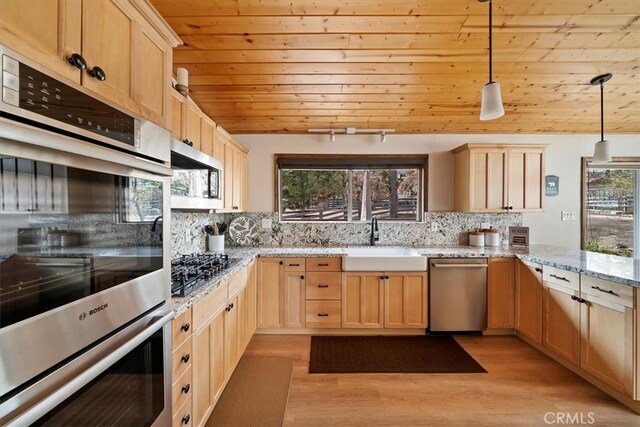 kitchen featuring a sink, wood ceiling, light brown cabinetry, and stainless steel appliances