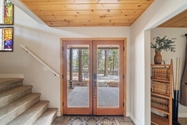 entryway with french doors, vaulted ceiling, wooden ceiling, baseboards, and stairs