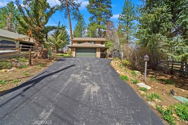 traditional-style house featuring fence and aphalt driveway
