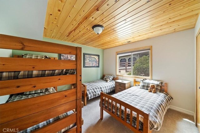 carpeted bedroom featuring baseboards and wood ceiling