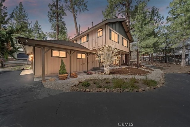 exterior space featuring board and batten siding and fence