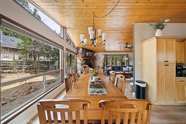 dining area featuring a healthy amount of sunlight, wooden ceiling, light wood-style floors, and lofted ceiling