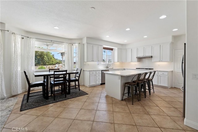 1732 Gamble Ln, Escondido, CA 92029 - kitchen with a center island, under cabinet range hood, white cabinets, light countertops, and recessed lighting
