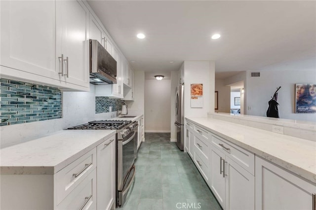 kitchen featuring visible vents, backsplash, white cabinets, and stainless steel appliances