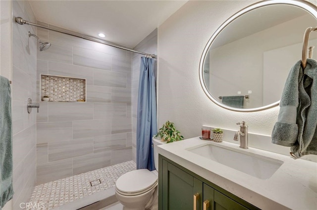 bathroom with vanity, recessed lighting, toilet, and tiled shower