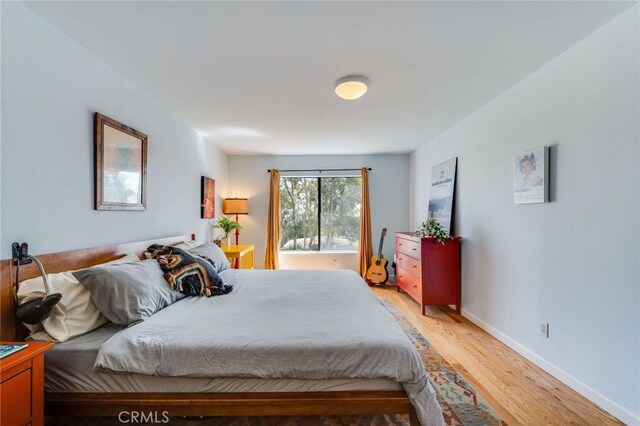 bedroom with light wood-type flooring and baseboards