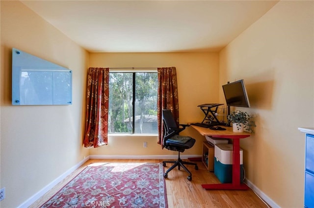 home office featuring baseboards and wood finished floors