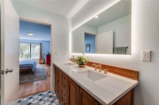 ensuite bathroom featuring double vanity, a sink, and ensuite bath