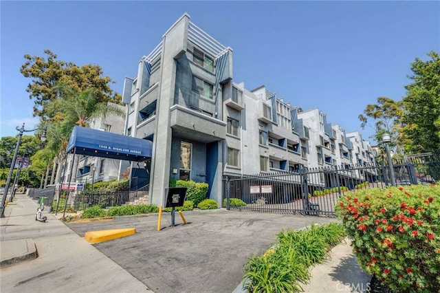 view of building exterior featuring fence, uncovered parking, and a residential view