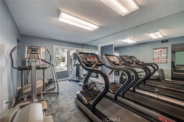 gym with dark colored carpet, a textured ceiling, and visible vents