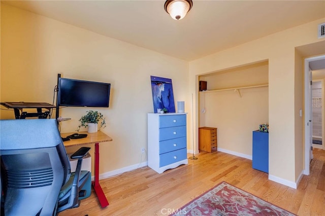 office area with baseboards, light wood-style flooring, and visible vents