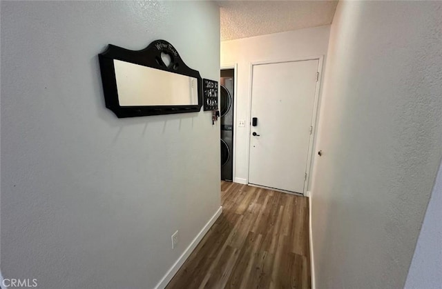 1920 S Mcclelland St Unit 27A, Santa Maria, CA 93454 - hall featuring estacked washer and dryer, wood finished floors, baseboards, a textured ceiling, and a textured wall