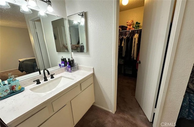 1920 S Mcclelland St Unit 27A, Santa Maria, CA 93454 - bathroom featuring vanity, a spacious closet, a textured wall, and a textured ceiling