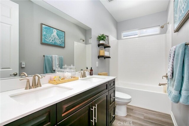 6335 Oldfield St, Lancaster, CA 93536 - bathroom with double vanity, bathtub / shower combination, and wood finished floors