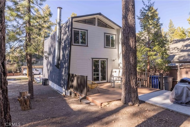 back of house featuring fence and a deck
