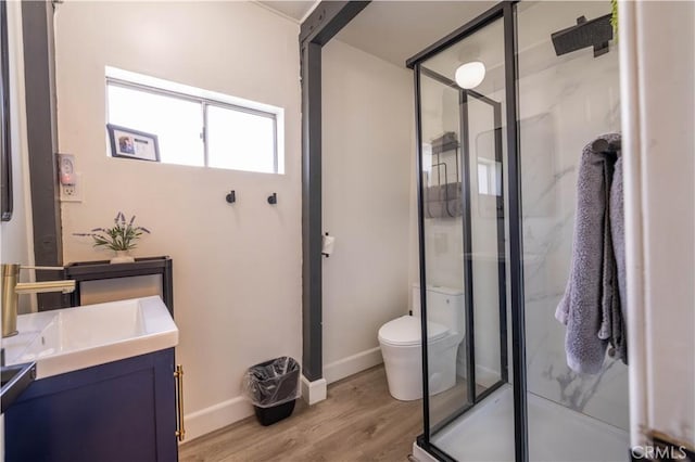 full bathroom featuring a shower stall, toilet, vanity, and wood finished floors