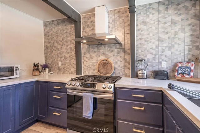 kitchen featuring wall chimney exhaust hood, decorative backsplash, stainless steel range with gas stovetop, and white microwave