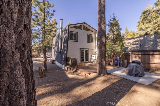 back of property with fence and a deck