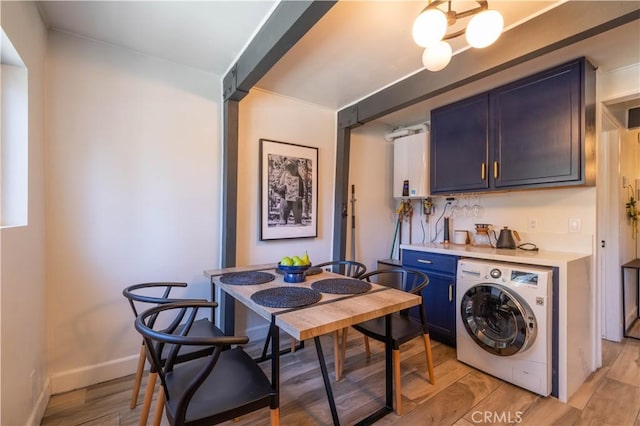 interior space featuring washer / dryer, light wood-type flooring, baseboards, and a dry bar