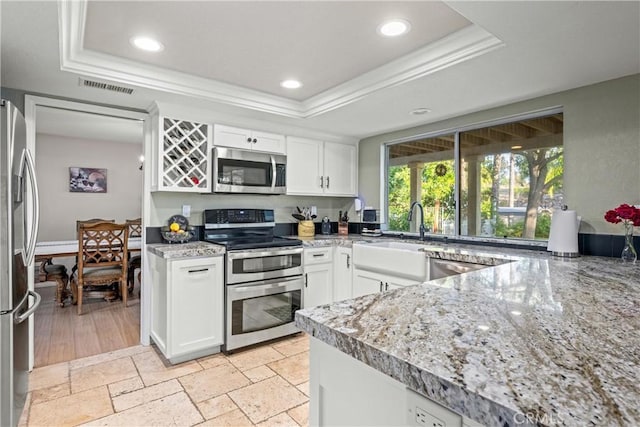 28863 Capano Bay Ct, Menifee, CA 92584 - kitchen featuring appliances with stainless steel finishes, a tray ceiling, a sink, white cabinets, and recessed lighting