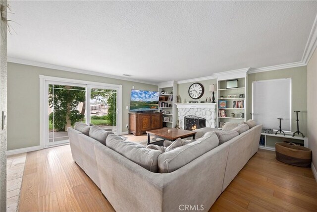 28863 Capano Bay Ct, Menifee, CA 92584 - living room featuring a textured ceiling, a premium fireplace, light wood-style floors, baseboards, and ornamental molding