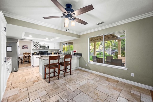28863 Capano Bay Ct, Menifee, CA 92584 - kitchen featuring stainless steel appliances, ornamental molding, a peninsula, white cabinets, and a breakfast bar area