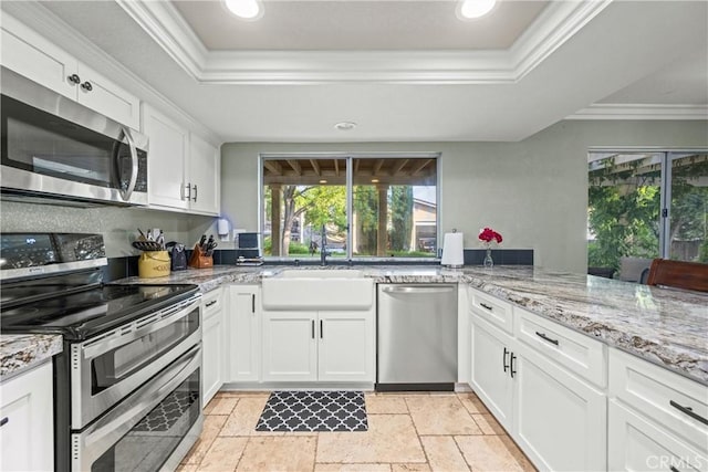 28863 Capano Bay Ct, Menifee, CA 92584 - kitchen with stainless steel appliances, a raised ceiling, a sink, crown molding, and stone tile flooring