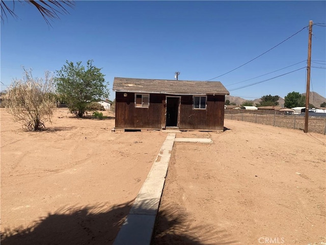 bungalow-style home with an outbuilding, a shed, and fence
